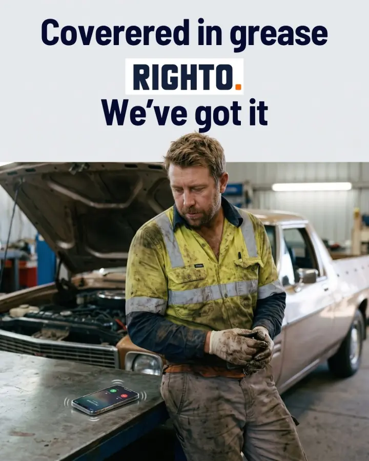 Mechanic covered in grease beside a ringing phone